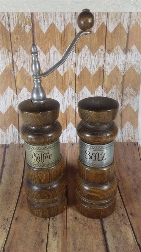 Two Salt And Pepper Shakers Sitting On Top Of A Wooden Table