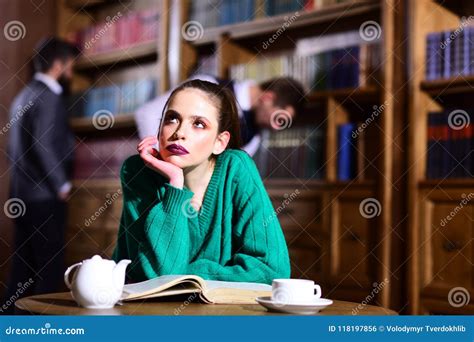 Frau In Der Bibliothek Las Buch An Trinkendem Kaffee Der Teekanne Von