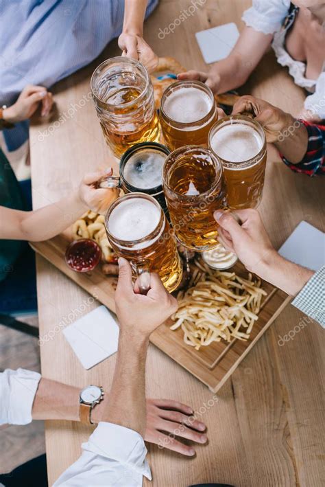 Vista Recortada De Amigos Multiculturales Tazas Tintineo De Cerveza