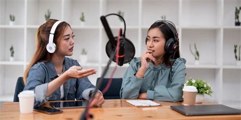 Asian Female Host Recording Radio Podcast Interview With Guest At Home