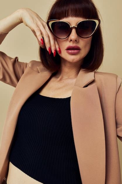 Premium Photo Young Woman Wearing Sunglasses Standing Against Wall