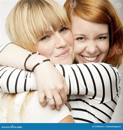 Het Rode En Blonde Haired Meisjes Lachen En Omhelzing Stock Afbeelding