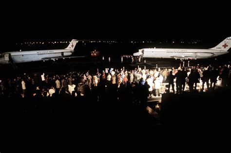 Spectators watch two C-9 Nightingale aircraft bringing in the 52 freed ...