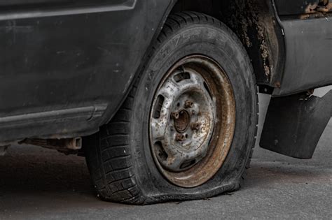 Premium Photo | A flat tire on an old rusty car flat tire old rusty car ...