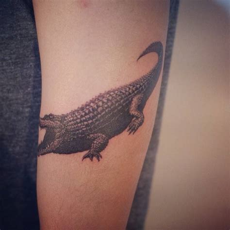 Crocodile tattoo on the left upper arm.