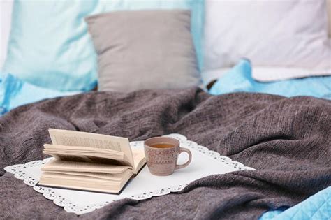 Premium Photo Cup Of Hot Drink And Book On Bed