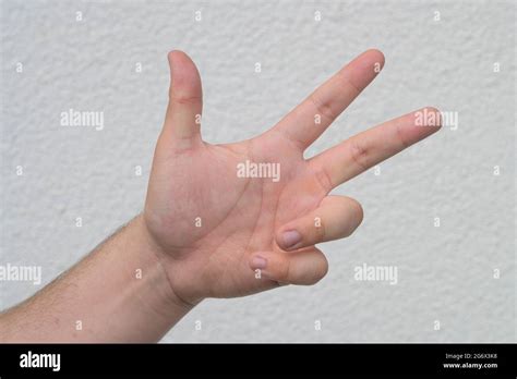 Man Holding Up Three Finger On His Hand Over White In A Counting Or