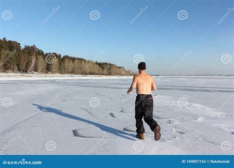 Man In A Cap With A Naked Torso Running Across The Ice Of A Frozen River Stock Photo Image Of