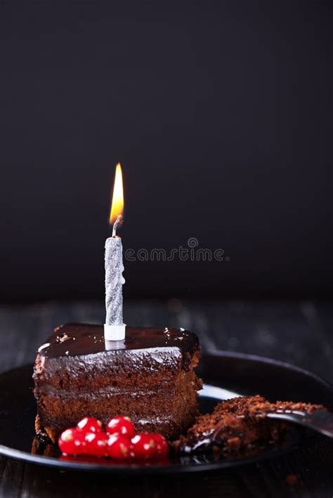 Slice Of Chocolate Cake With A Single Lit Candle Stock Photo Image