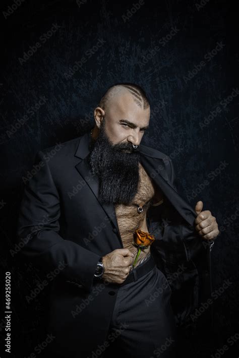 Stylish Handsome Man With A Black Beard In A Black Suit With A Naked Torso And Hairy Chest