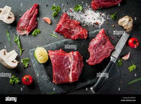 Fresh Raw Beef Meat Tenderloin Steaks On A Slate Cutting Board On Black Stone Table With Spices