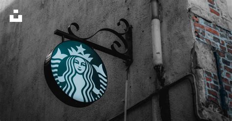 A starbucks sign on the side of a building photo – Free België Image on ...