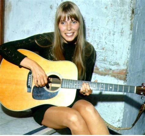 a woman sitting on the ground with an acoustic guitar in her hand and ...