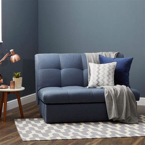 a living room with blue walls and wooden flooring is pictured in this image, the couch has ...