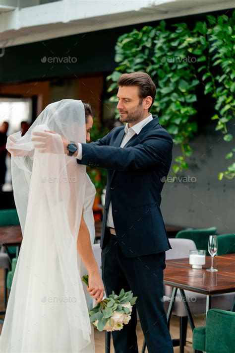 Happy Lovers The Groom Lifts Veil Of The Bride In White Dress At The