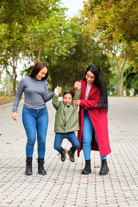 Colombian Lesbian Couple Playing With Their Son In A Park Stock Photo By Ladanifer
