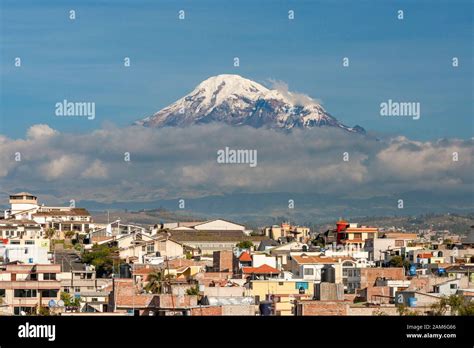 Mount Chimborazo volcano (6268m) seen across the rooftops of the town ...