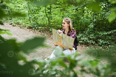 Portrait D Une Jeune Blonde Magnifique Positive Assise Sur Le Sol Avec Une Carte Dans Les Mains