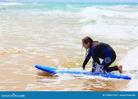 Adolescente En El Aprendizaje Azul Practicar Surf Foto De Archivo