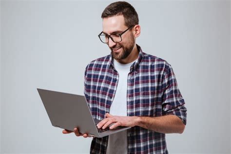 Hombre Barbudo Sonriente En Eyeglases Usando Laptop Foto Gratis