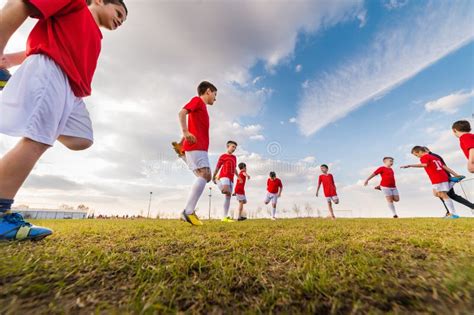 Meninos Que Jogam O Jogo De Futebol Do Futebol No Campo De Esportes