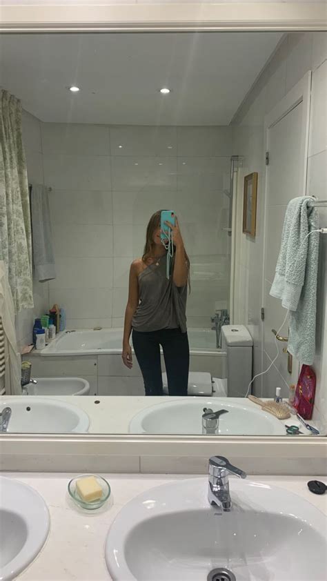 A Woman Taking A Selfie In Front Of A Bathroom Mirror With Two Sinks