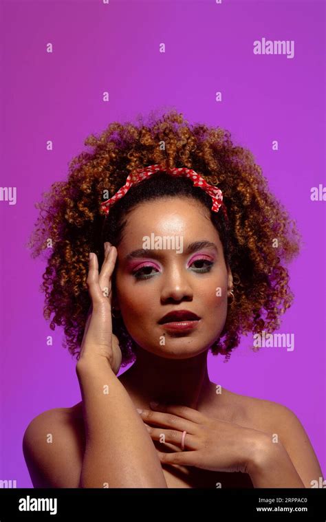 Biracial Woman With Pink Eye Shadow And Lipstick Touching Face Purple