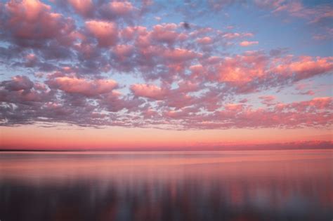 Premium Photo Clouds Reflected On The Water During Sunset