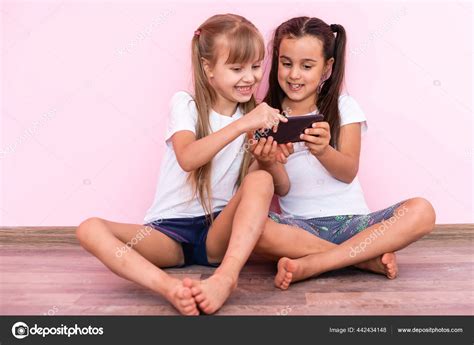 Deux Petites Filles Jouant Avec Des Smartphones Sur Un Fond Rose Image