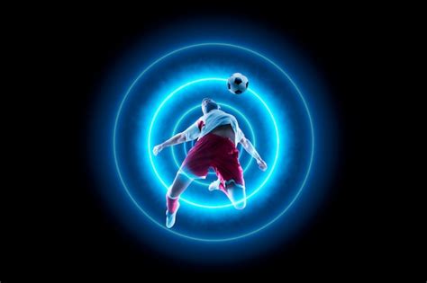 Jogador de futebol está driblando a bola luz de neon azul Foto