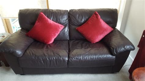 Good condition 3 and 2 seater dark brown leather sofas. Cushions are ...