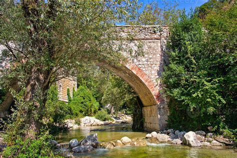 Old Stone Arch Bridge Over A Small River In The Alps 12055287 Stock