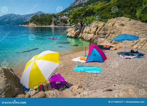 Amazing Gravelly Beach With Colorful Parasols And Towels Stock Image