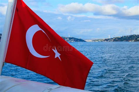 Turkish Flag In The Wind Blurred Cityscape Of Istanbul And Bosporus