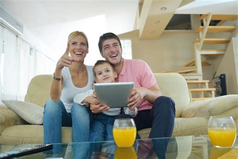 Familia Joven Feliz Que Usa Una Tableta En Un Hogar Moderno Para Jugar