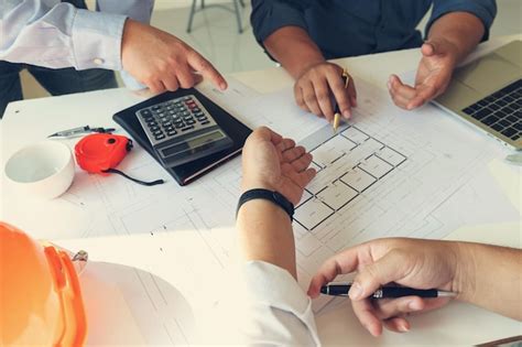 Premium Photo Midsection Of Engineers Working Over Plan In Office