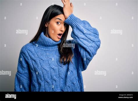 Jeune femme belle brunette portant un pull décontracté à col roulé sur fond blanc surpris par la