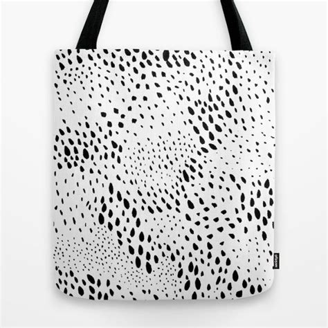 A Black And White Tote Bag With Spots On The Front In An Abstract Manner