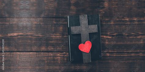 Holy Bible. On the table. Cross crucifix and red heart. The concept of God's love. On a wooden ...