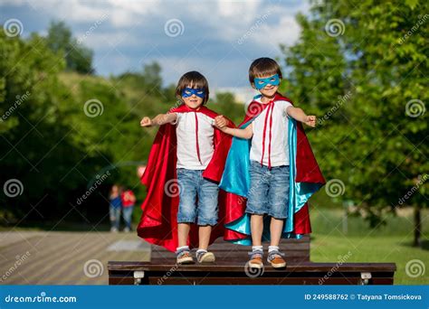 Two Sweet Little Preschool Children Boys Playing Superhero In The