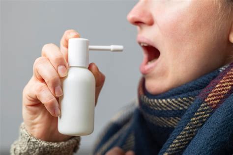 Premium Photo A Woman With A Sore Throat Sprays Medicine Aerosol