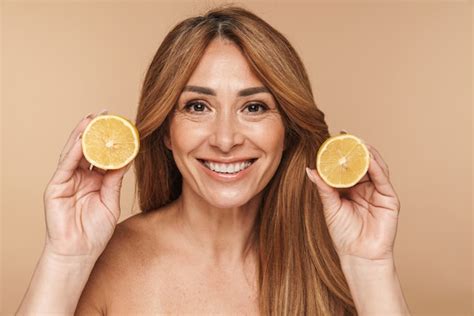 Premium Photo Portrait Of Half Naked Adult Woman Holding Lemon And Smiling Isolated On Beige