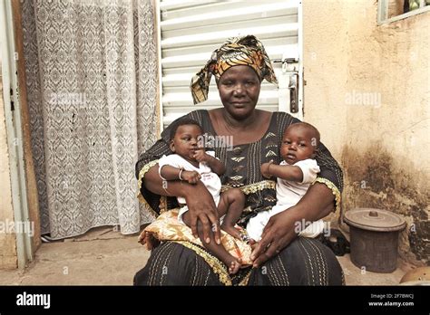 Africa /Mali/Bamako//African woman holding baby twins in her arms Stock ...