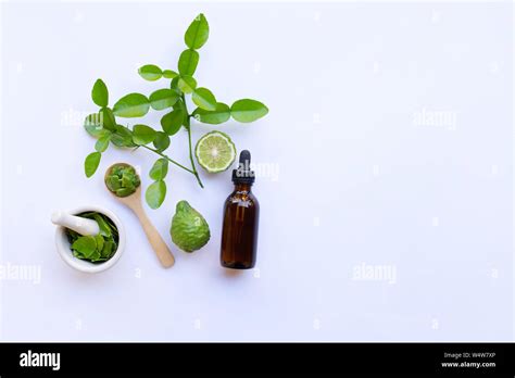 Bottle Of Essential Oil And Fresh Kaffir Lime Or Bergamot Fruit With Leaves Isolated On White