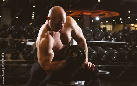 Muscular Man With Naked Torso Working Out In Gym Doing Exercises With Dumbbell At Biceps Strong
