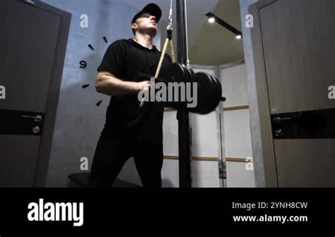 Pumping triceps of men's arms. Athlete in a home gym. A young athlete ...