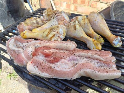 Corn Fed Chicken Thighs And Drumsticks With Outdoor Pork Belly Prepared On A Charcoal Grill