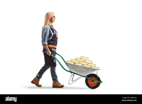 Full Length Profile Shot Of A Female Gardener Pushing A Wheelbarrow