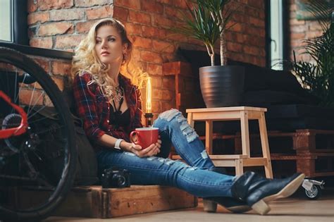 Fille hipster blonde sensuelle aux longs cheveux bouclés vêtue d une chemise polaire et d un