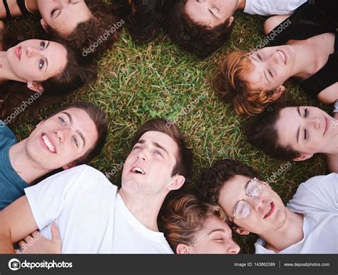 Young people lying on grass Stock Photo by ©juripozzi 143862389